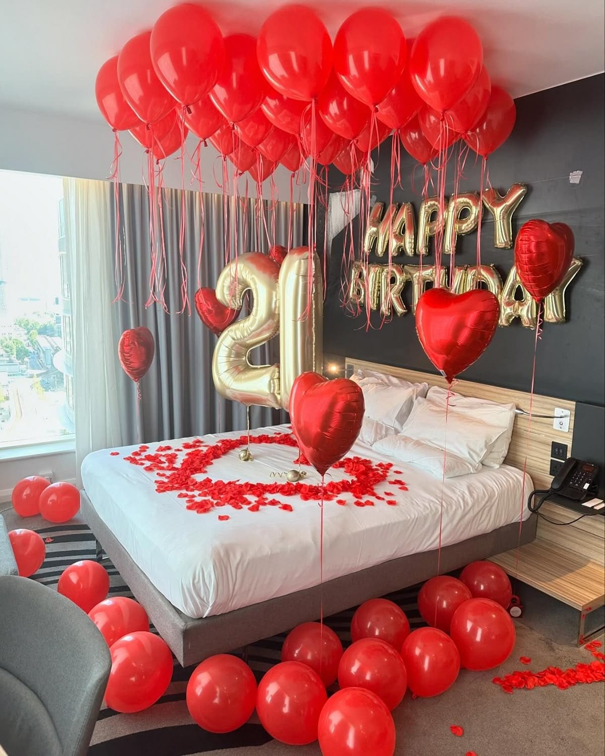 Red balloon '21' birthday styling in a hotel room