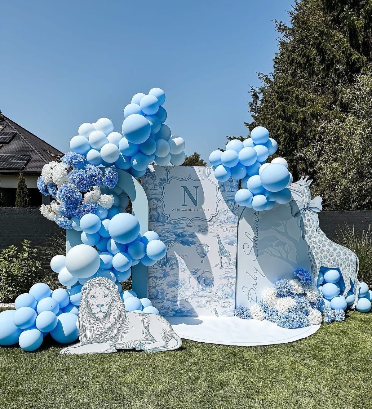 Blue and white balloon arch with a decorative lion feature