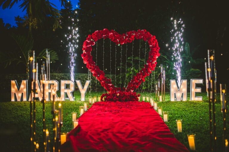 Illuminated heart and 'Marry Me' letters with fireworks