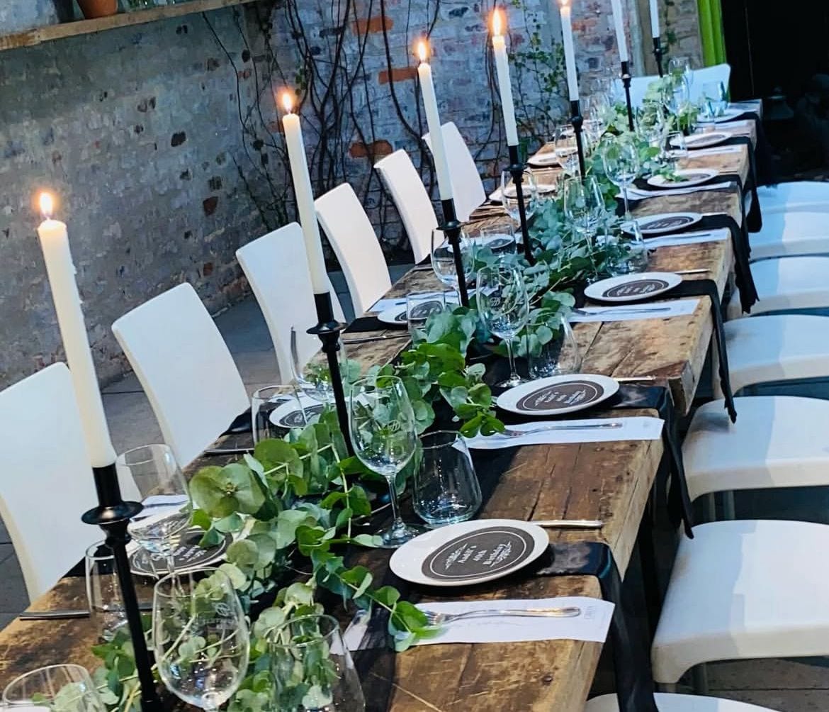 Candlelit rustic table with trailing greenery