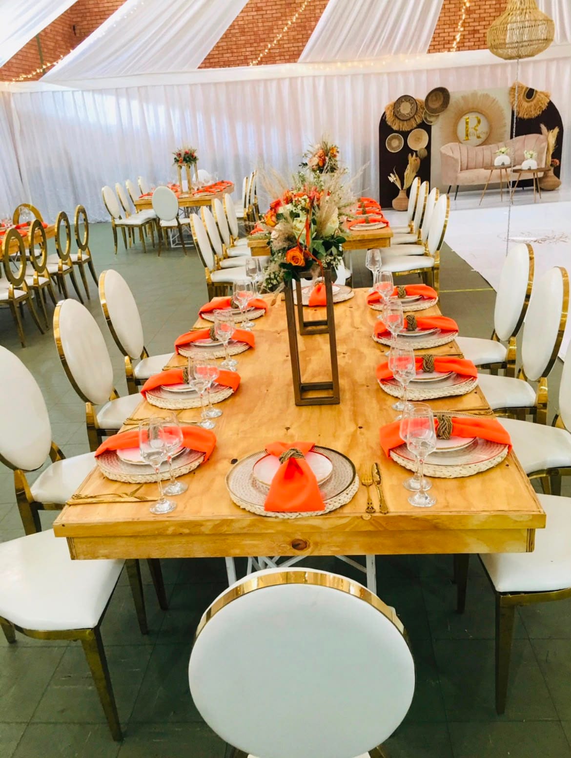 Indoor reception table with gold chairs and warm florals